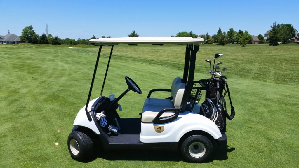 A golf cart on a fairway, seen from behind